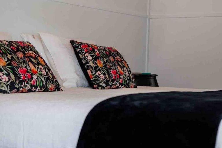 A queen bed at Bahche House with black and floral cushions